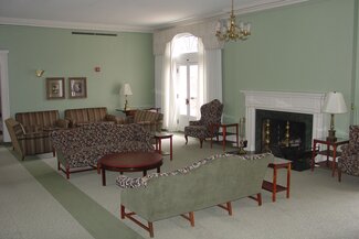 Busey Evans Lounge with old fashioned furniture, chandelier, fire place, drapes