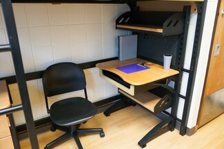 Lofted bed with desk and rolling chair underneath
