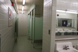 Communal bathroom with sinks, private shower stalls 
