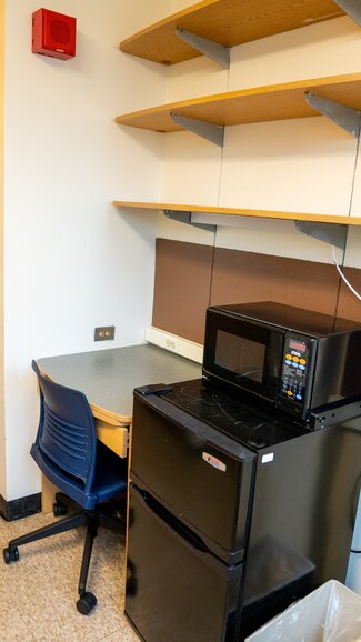 Sherman desk with rolling chair, shelving, fridge and microwave