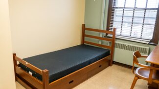Single room with bed, desk, chair and window
