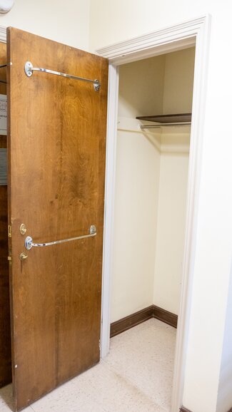 Closet with two towel rack on door and overhead storage