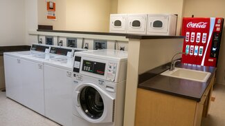 Laundry room with washers, dryers, soda machine, sink and counters