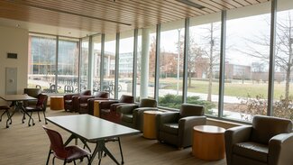 Main Lounge with chairs, tables and large windows looking onto Ikenberry Commons