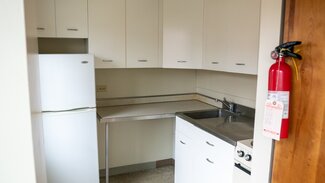 Kitchen with cabinets, counters, fridge, stove, sink, fire extinguisher