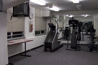 Exercise room with two elliptical machines, a stationary bike and a tv